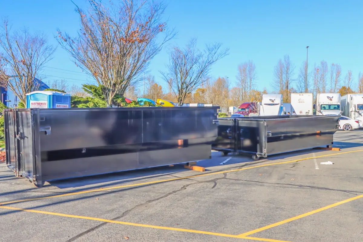 Professional dumpster rental service with roll-off container on residential driveway in Fletcher